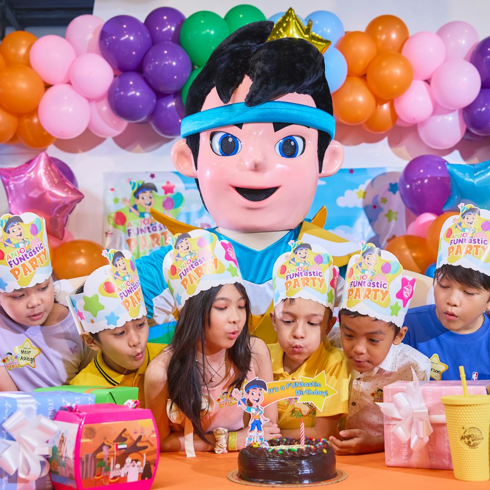 Anak-anak meniup lilin bersama maskot