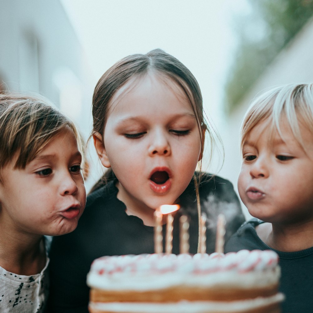 Anak-anak meniup lilin kue ulang tahun
